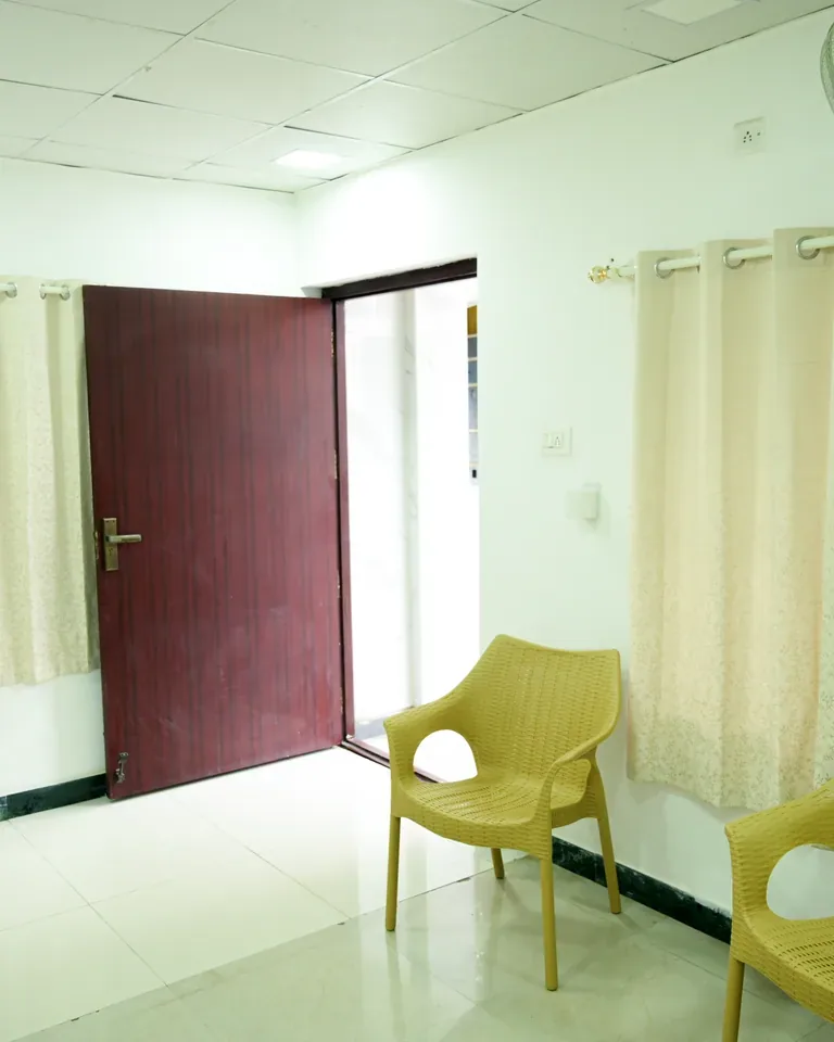 Clinic room with seating and an open doorway in Coimbatore